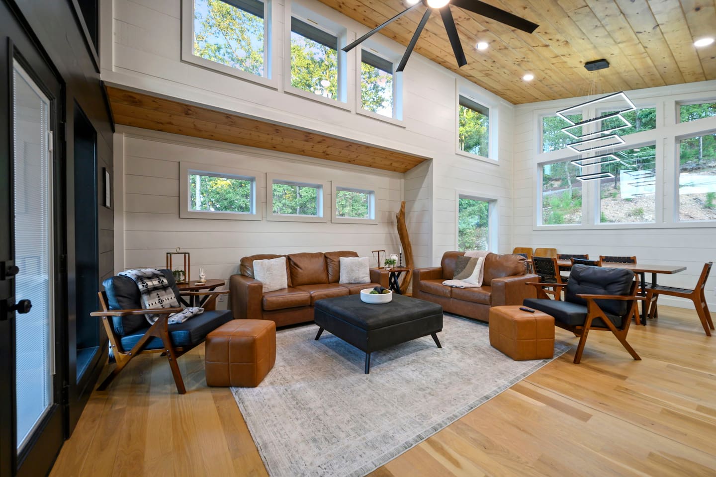 Upper-level living room with vaulted ceilings, large windows and space to gather.