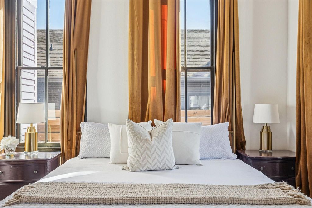 You’ll have sweet dreams in this roomy bedroom with original hardwood floors, tall windows that glow with natural light, and a calm, intimate atmosphere made for quiet nights and slow mornings. This charming suite shares ensuite access to a stunning full b