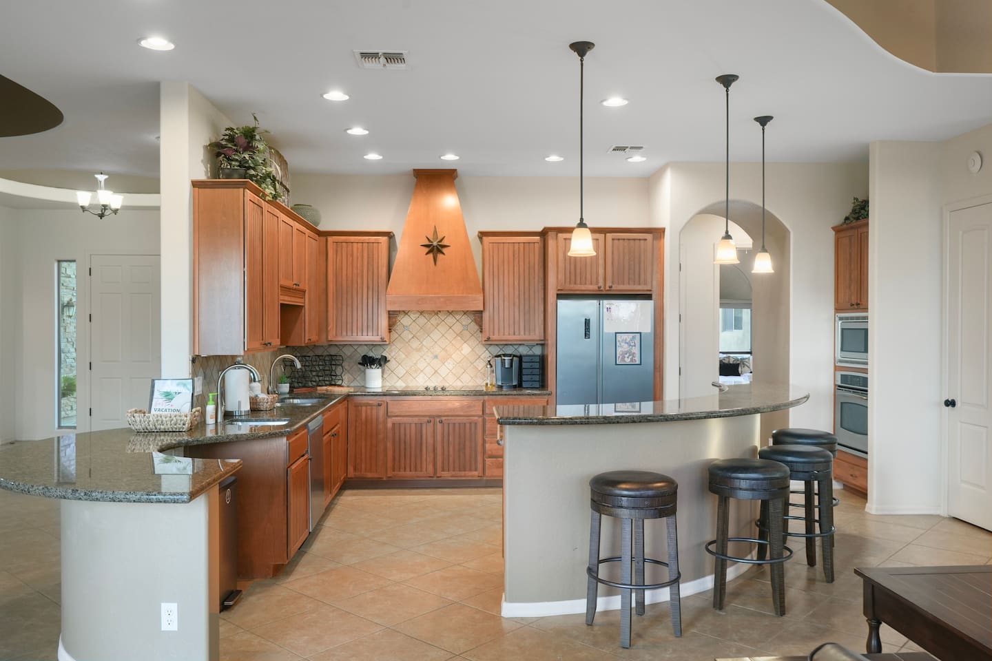 Spacious gourmet kitchen with granite countertops, custom cabinetry, and bar seating.