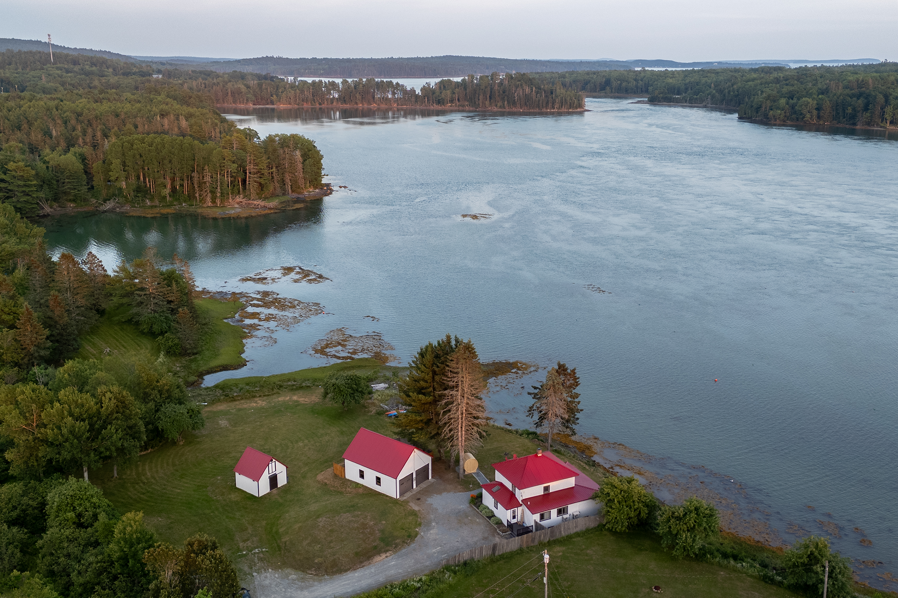 Take in the full picture from above — the property sits at the water's edge with the cove curving around the peninsula on three sides.