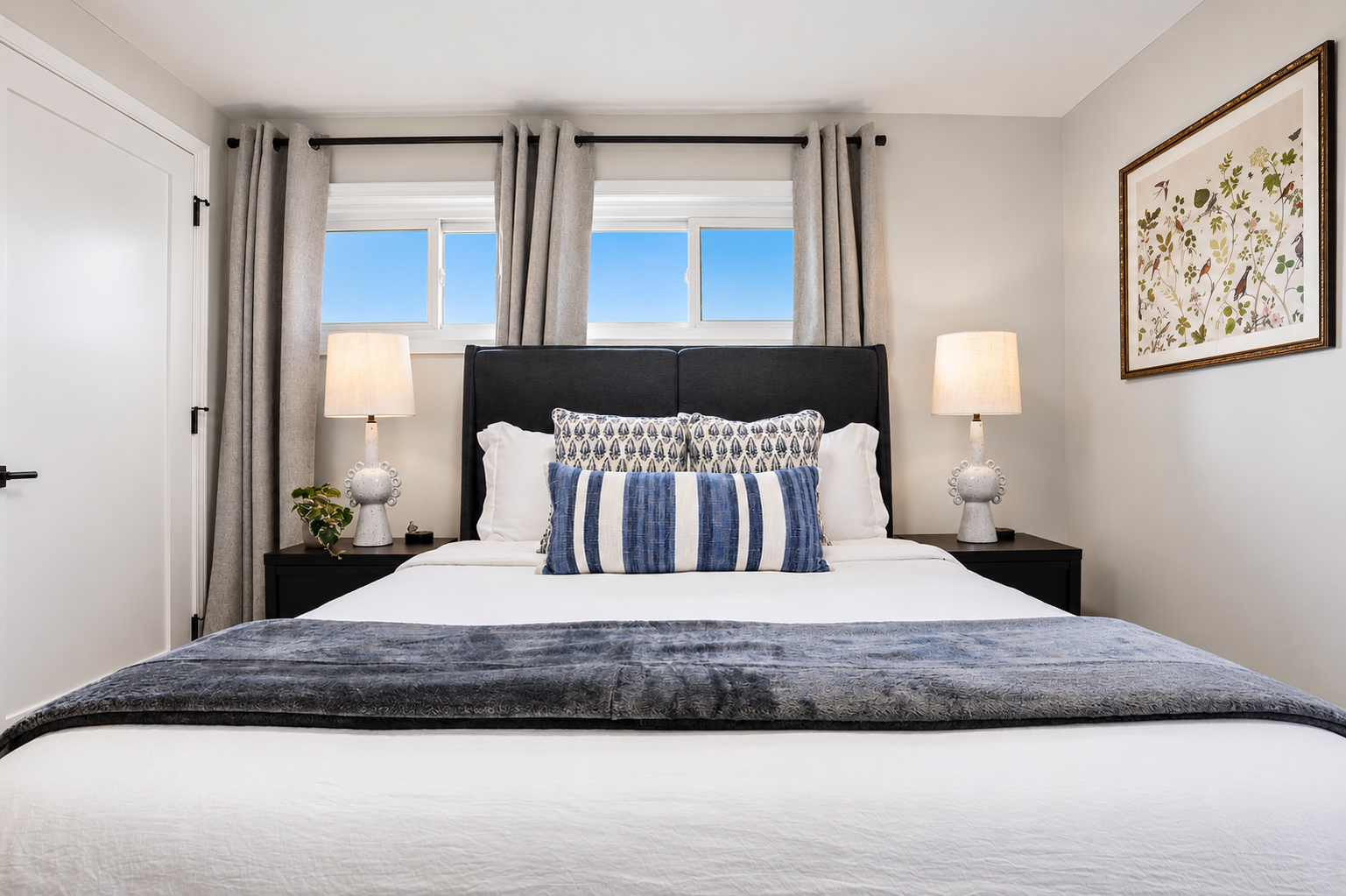This cozy bedroom features a comfortable bed, neutral decor, and large windows that fill the space with natural light, creating a calm and restful retreat.