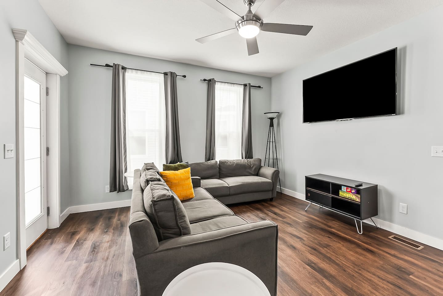 Unwind in the cozy living area featuring plush sofas, a large wall-mounted TV, and plenty of natural light.