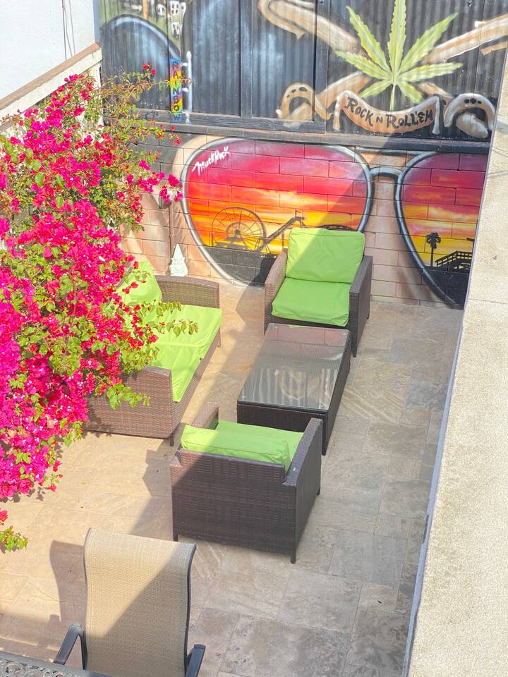 Sun-filled patio with lounge chairs and unique mural backdrop.