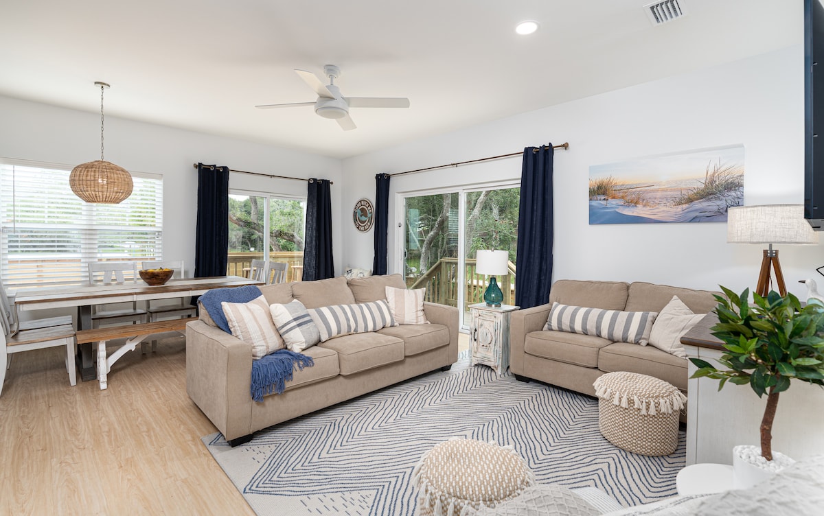 Sink into the sofa with the sliding doors open and the ceiling fan turning. This is where wet swimsuits get traded for dry clothes, where the card games happen, and where somebody falls asleep before the film ends.