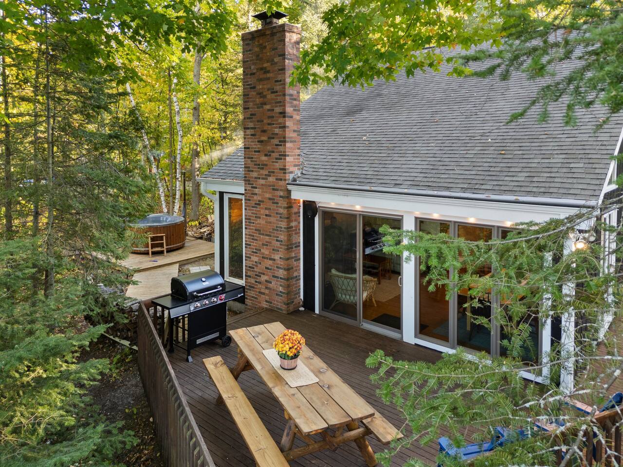 Back deck area including barbecue grill, table, and chairs.  Sound system on the back deck will connect to your device through bluetooth in just a few taps.  Peekaboo Lake Huron views from this spot also!