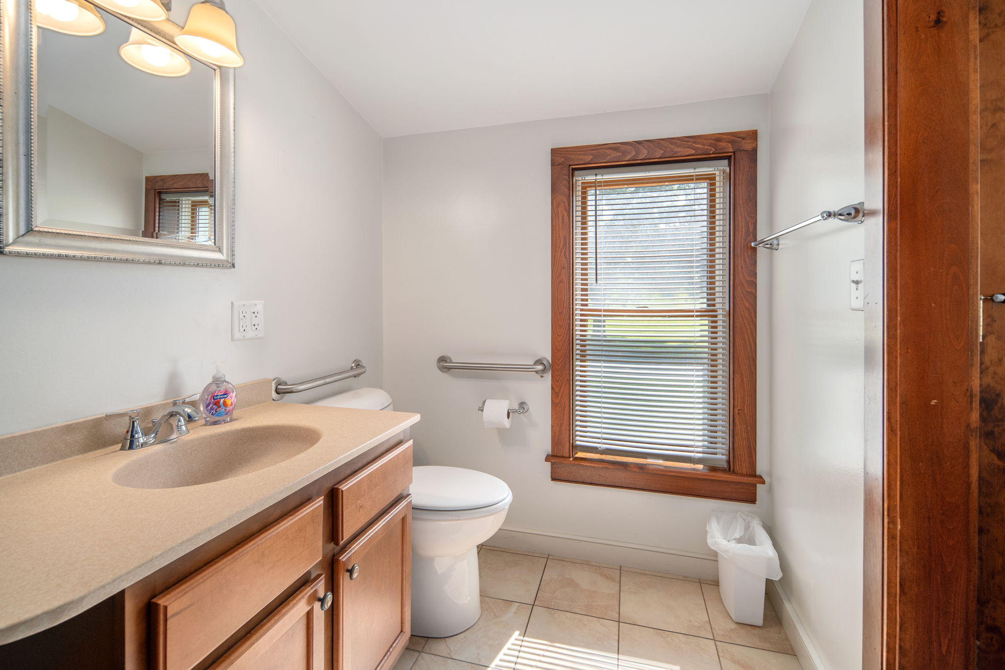 A practical bathroom layout with a vanity, shower, and towel storage.