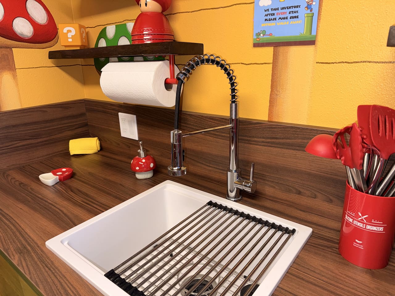 BRAND NEW! Practical and fun kitchen sink at Mario's Mini Mansion in Orlando area! Modern flexible faucet, white basin with drying rack, mushroom decor, and handy shelves make cleanup easy while staying immersed in the Nintendo-inspired adventure.