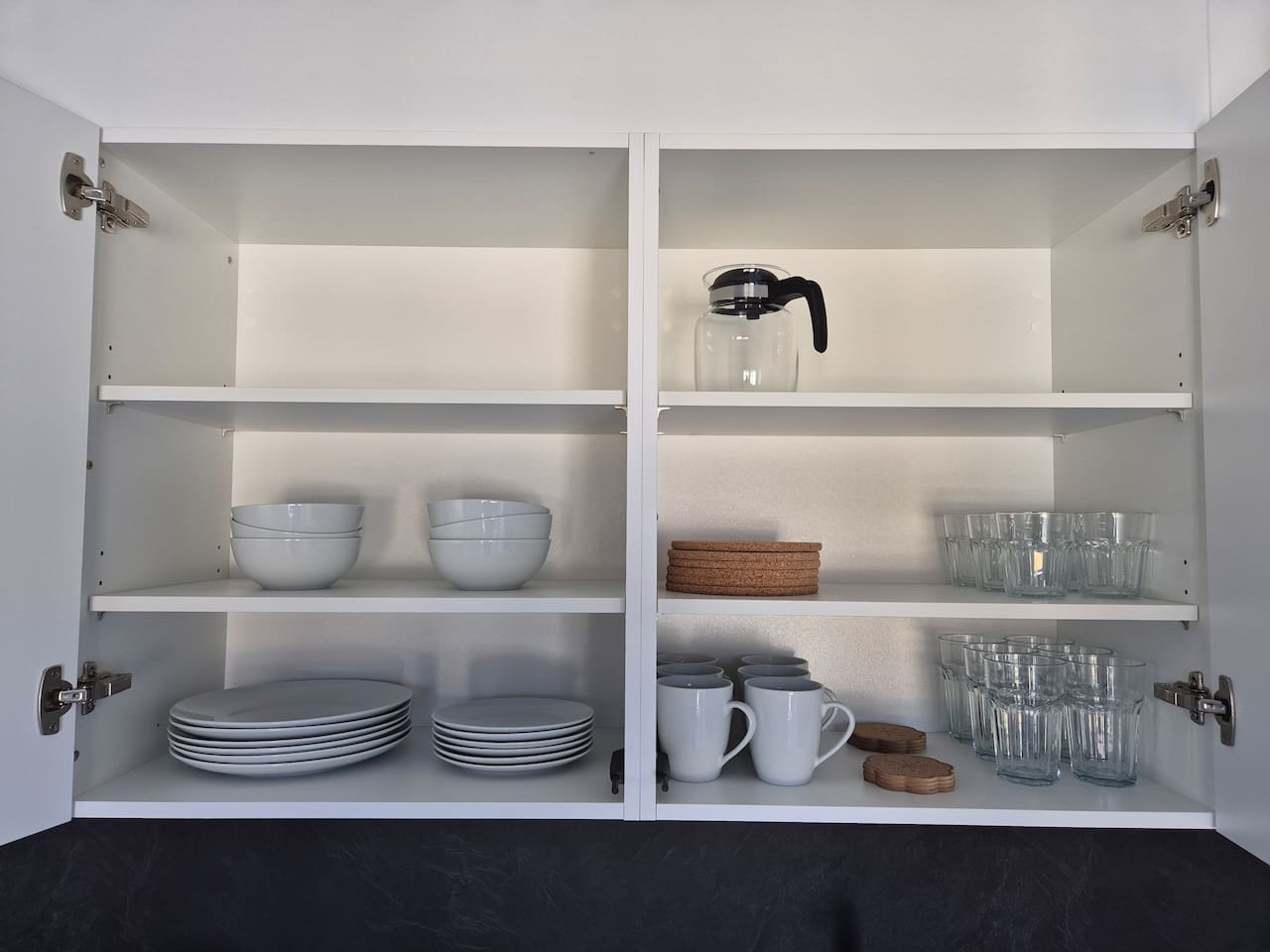 The kitchen comes equipped with plenty of plates, glasses and other daily necessities