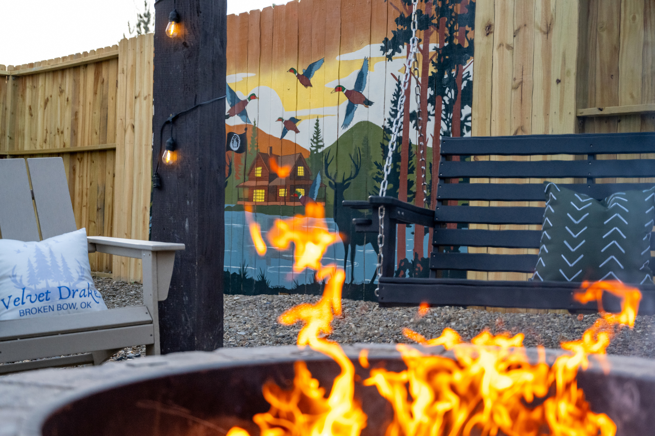 Outdoor Oasis: Enjoy evenings by the fire under a stunning mural and twinkling lights!
