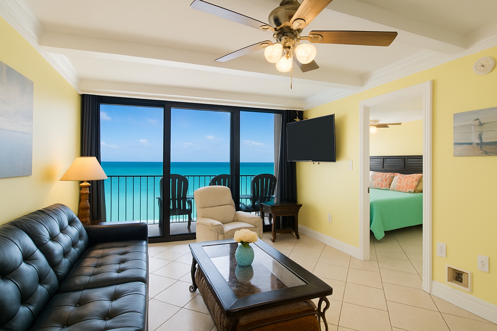 Living Room with A Great View. It Has A Queen Size Leather Sleeper Sofa, 2 Swivel/Rocker Recliners, 3 End Tables, A Coffee Table, A 58" Wall Mounted Smart TV And Balcony Access