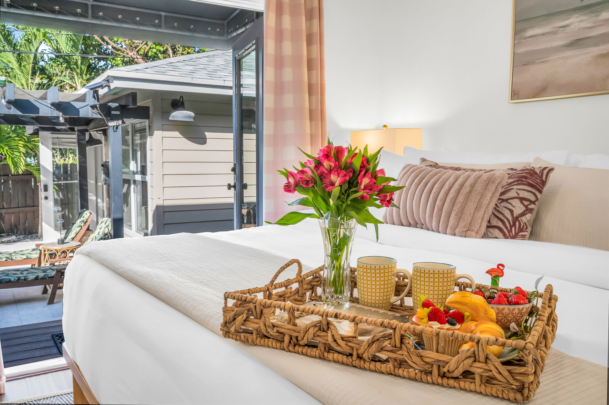 Serene king primary suite featuring a smart TV, private en-suite bathroom, and elegant French doors that open directly to the pool—perfect for seamless indoor-outdoor living and relaxing mornings or evenings.