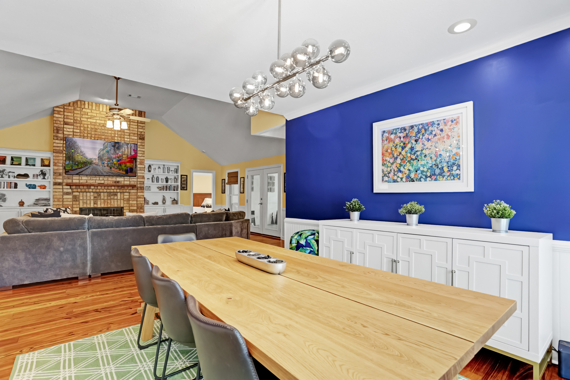 Modern dining area with bold accent wall, statement lighting, and a spacious table perfect for gathering, flowing seamlessly into the cozy living room.