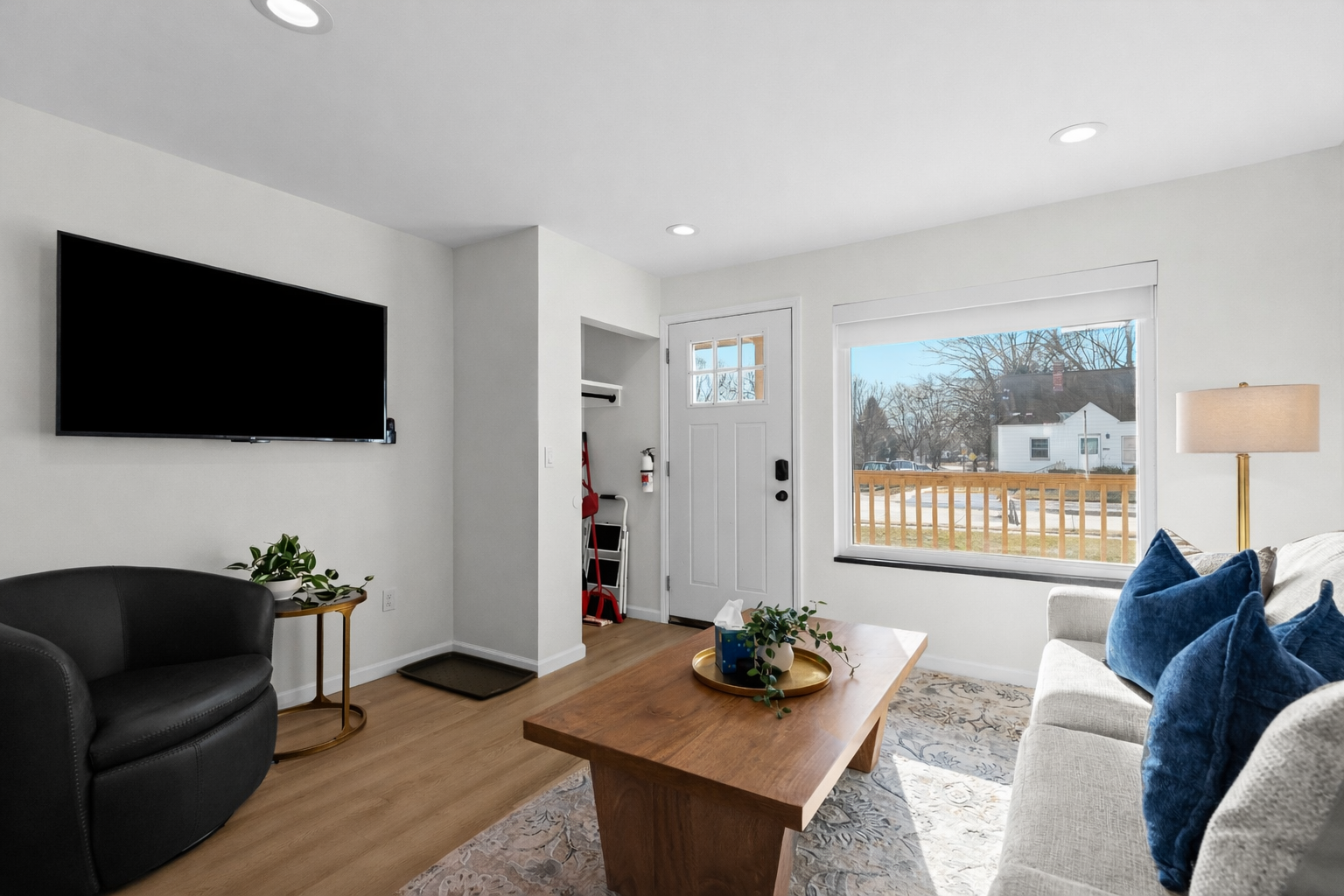 Spacious, light-filled living room with cozy seating, smart TV, and a bright window view—designed for comfort, relaxation, and easy living.