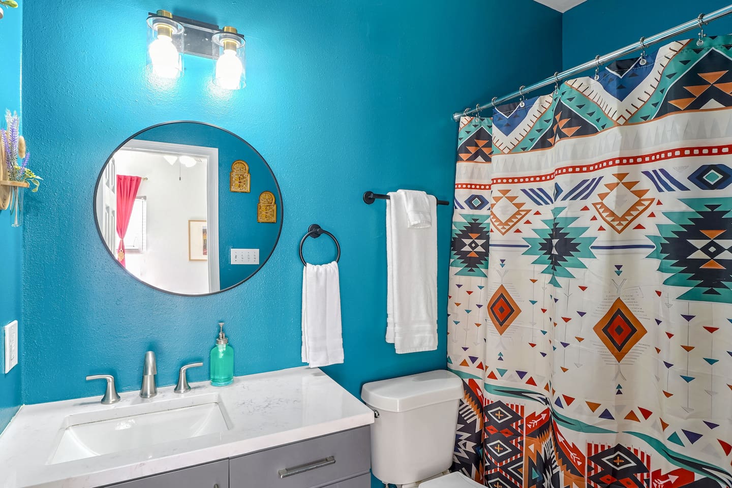 Vibrant downstairs master en suite with modern fixtures, spacious vanity, & chic Southwestern decor