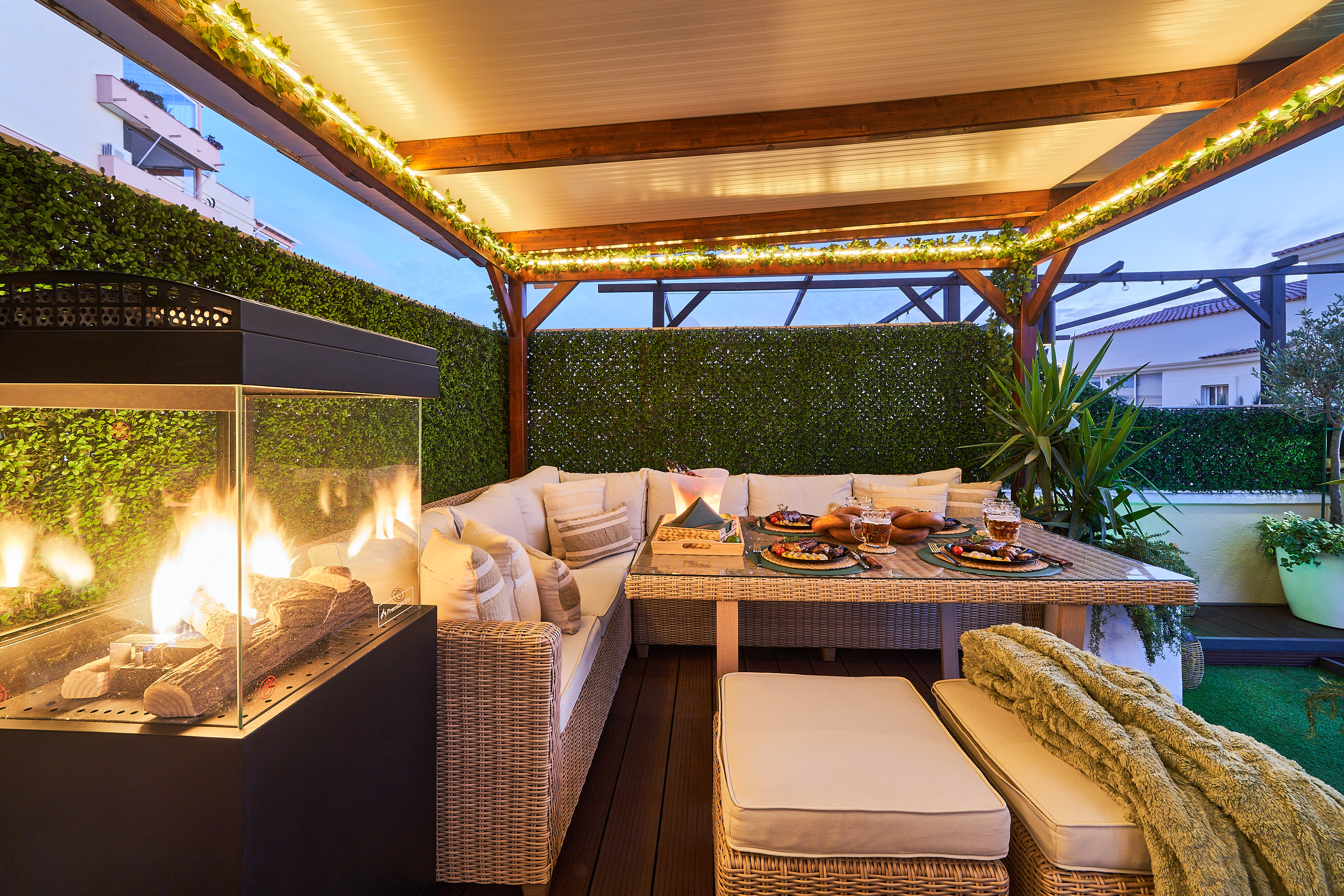 Relax beneath the covered pergola with cozy seating, fireplace, and dining area. Perfect for long evenings, romantic dinners, or movie nights on the outdoor TV under soft ambient lights.