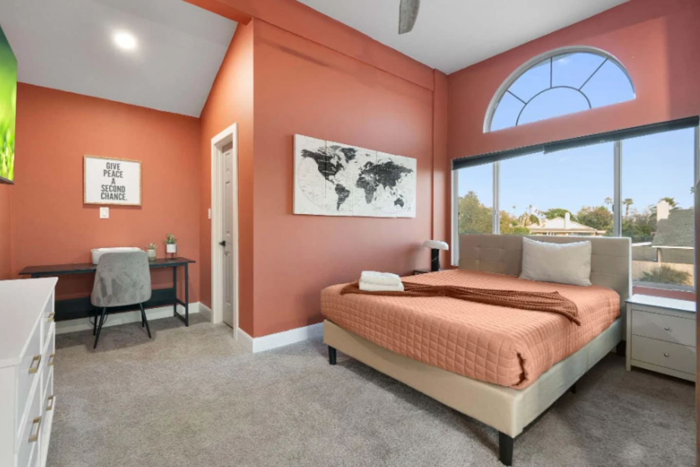 Bright, stylish bedroom with a dedicated workspace and expansive views.