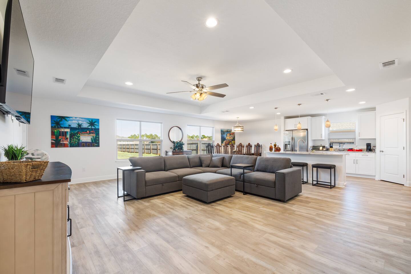 From the entrance hallway, a view of the living room, with the dining room in the back and kitchen to the right.