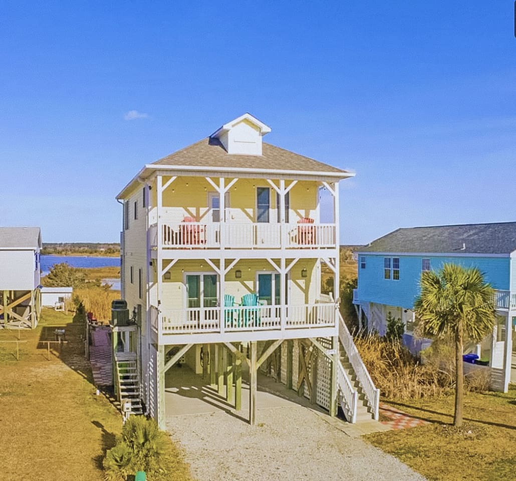Right across the street from two beach accesses! 
Watch the sunrise over the ocean on the front porch, & the sunset over the intercoastal from your back porch. Firepit & grill in your backyard.Stocked beach gear, kitchen, baby supplies, games, more!
