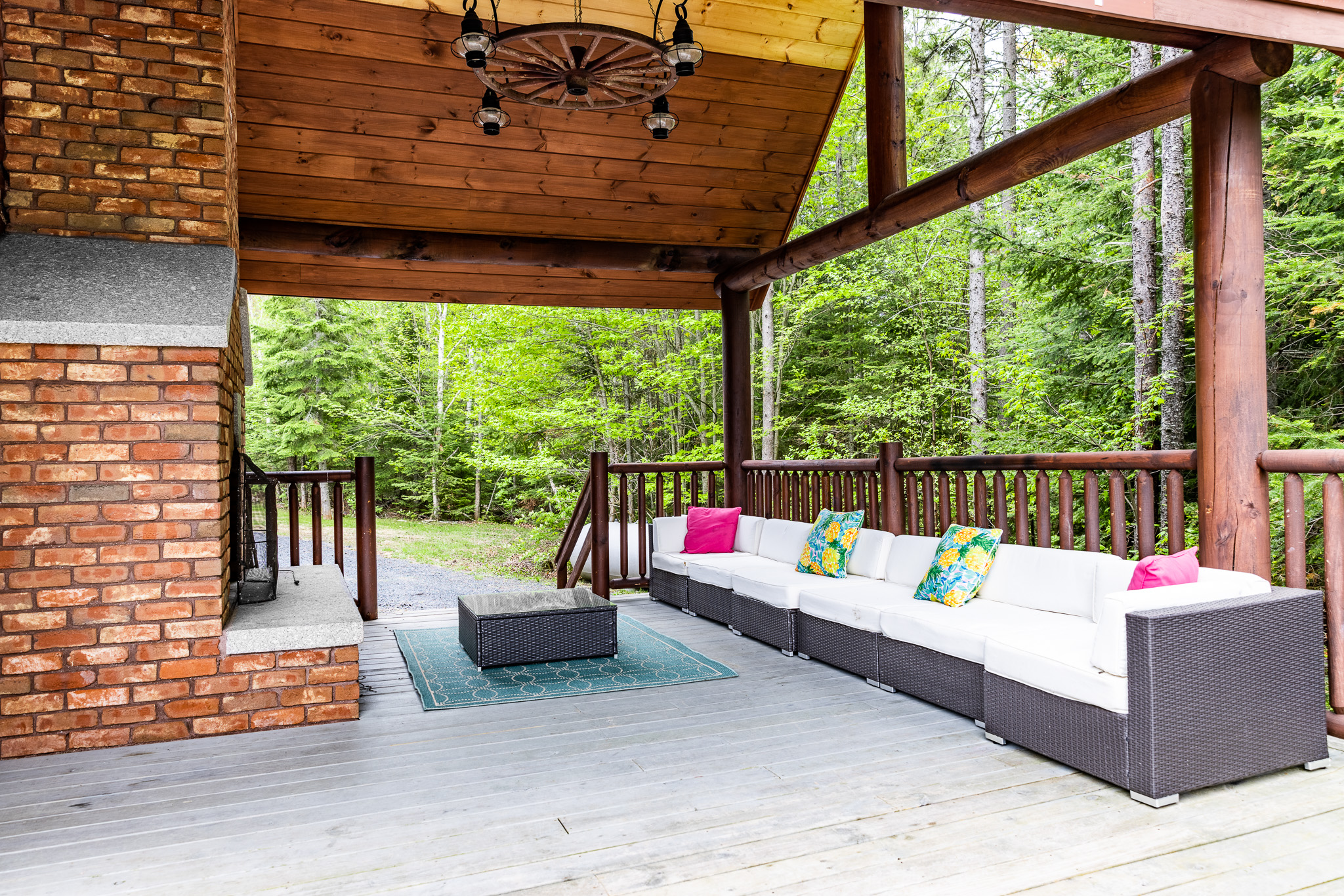 Outdoor fireplace with a seating area overlooking the lake equipped with gas grill, outdoor table for meals and covered by the roof so you can enjoy it rain or shine.