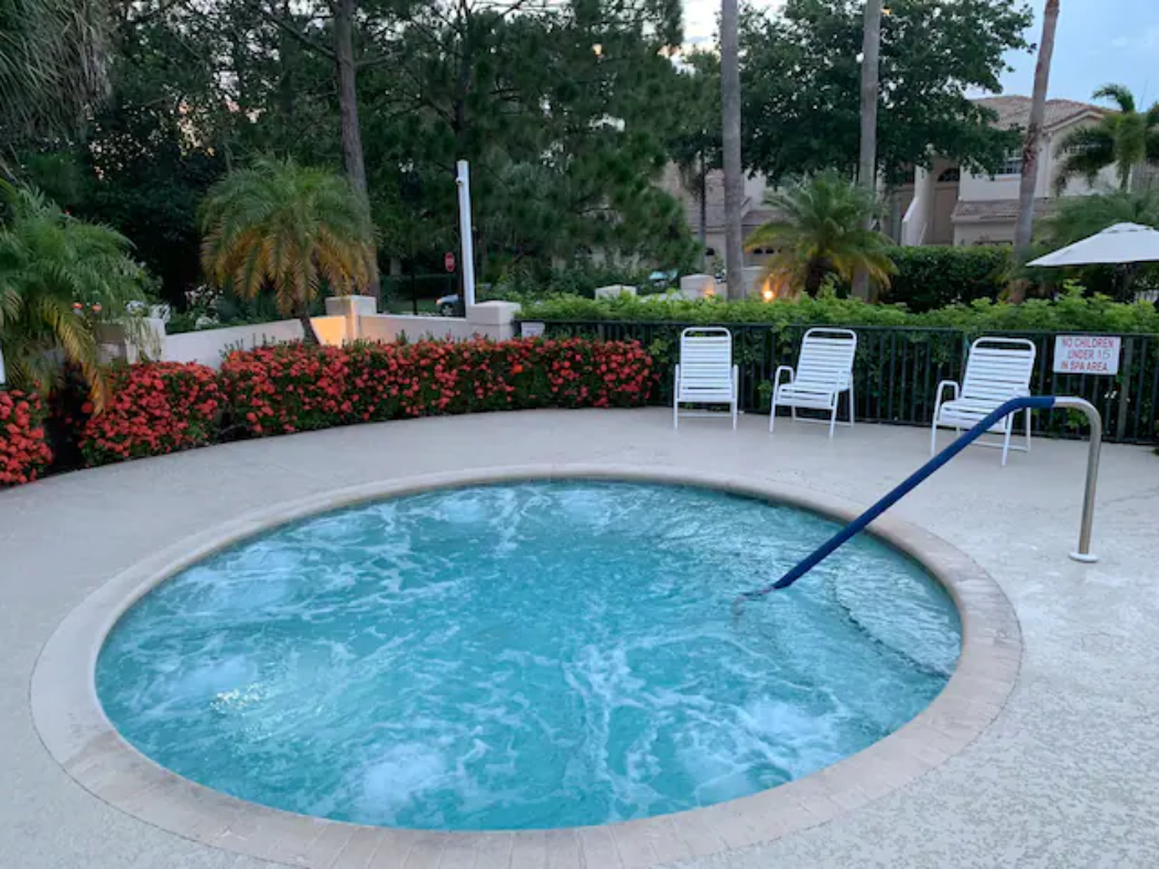 Relaxing community spa area surrounded by lush landscaping, perfect for unwinding after a day in the sun.