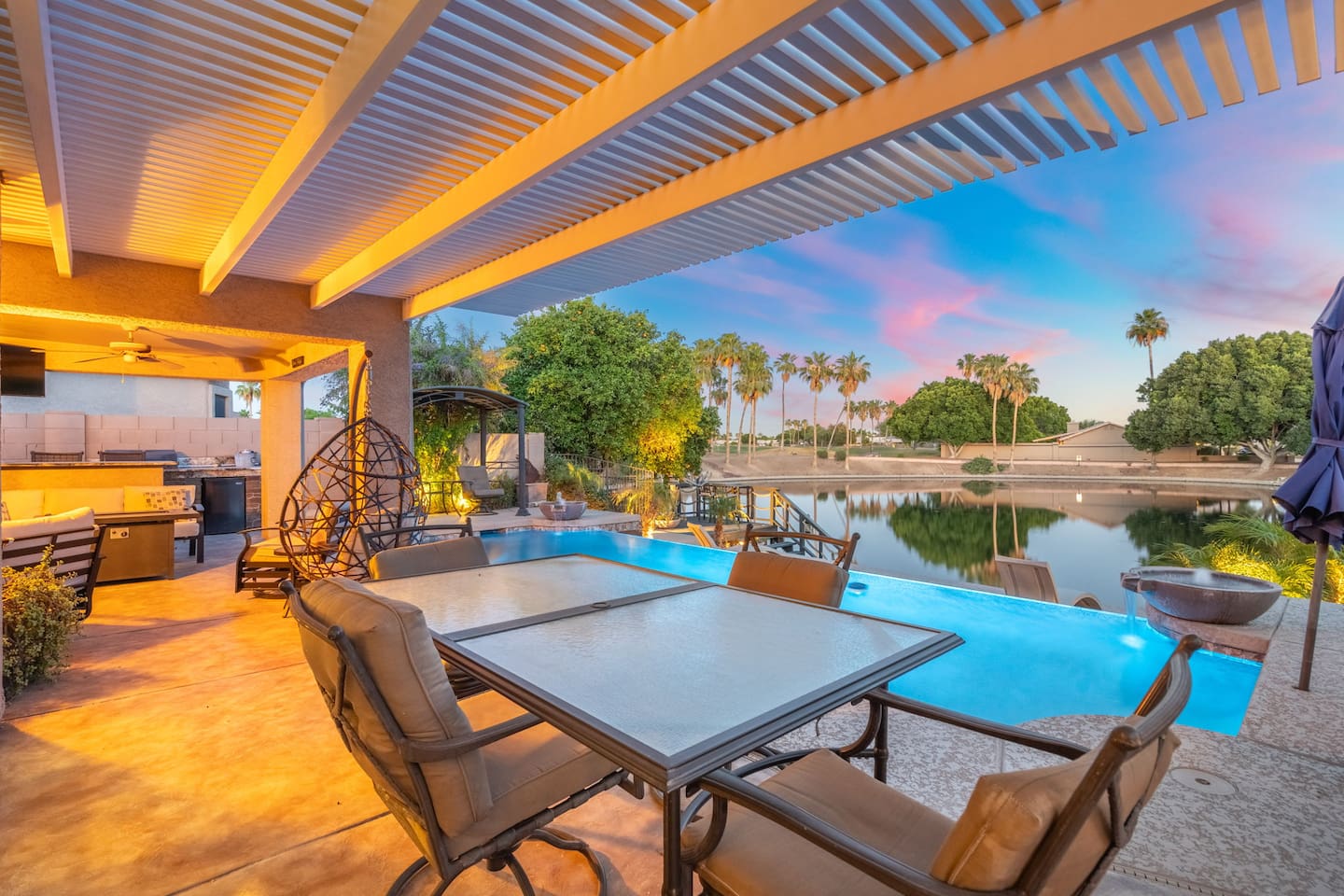  As the sun sets and the pool glows, the pergola-covered dining area becomes the most coveted table in the house — pull up a chair and let the evening unfold.