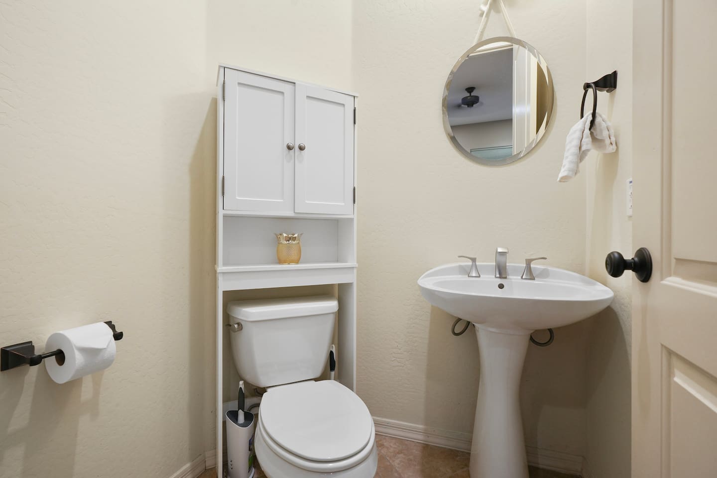 Private casita half bathroom with a pedestal sink, added storage cabinet, and clean modern finishes—perfect for guests enjoying extra privacy.