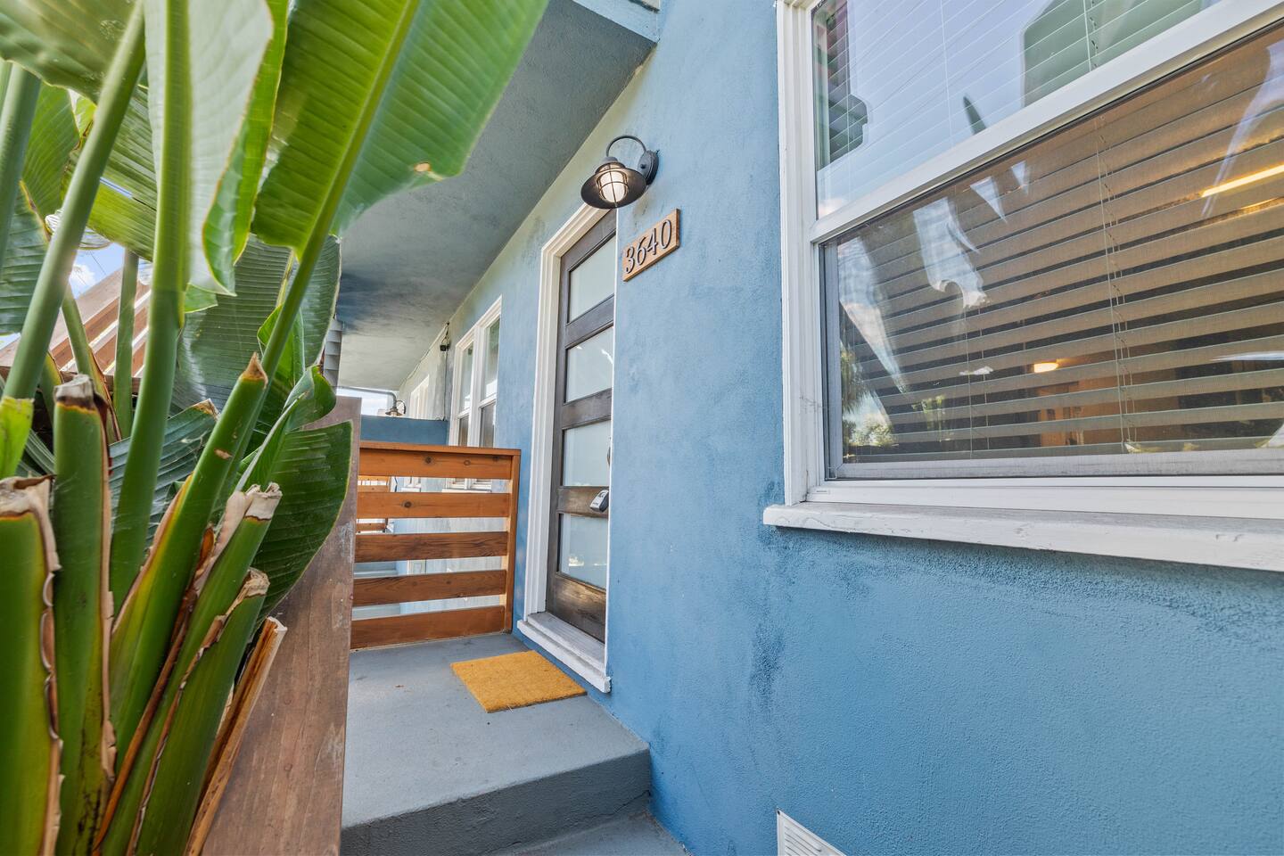 Step through a charming doorway that blends seamlessly with lush greenery outside. This inviting entrance, surrounded by vibrant plants, offers a refreshing welcome and a touch of nature as you enter the home.