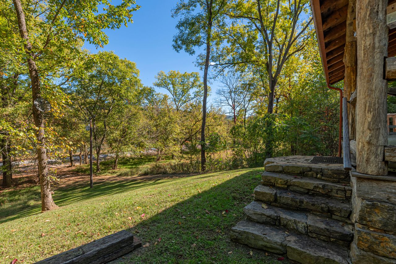 Large rock steps lead to the front porch of the cabin.