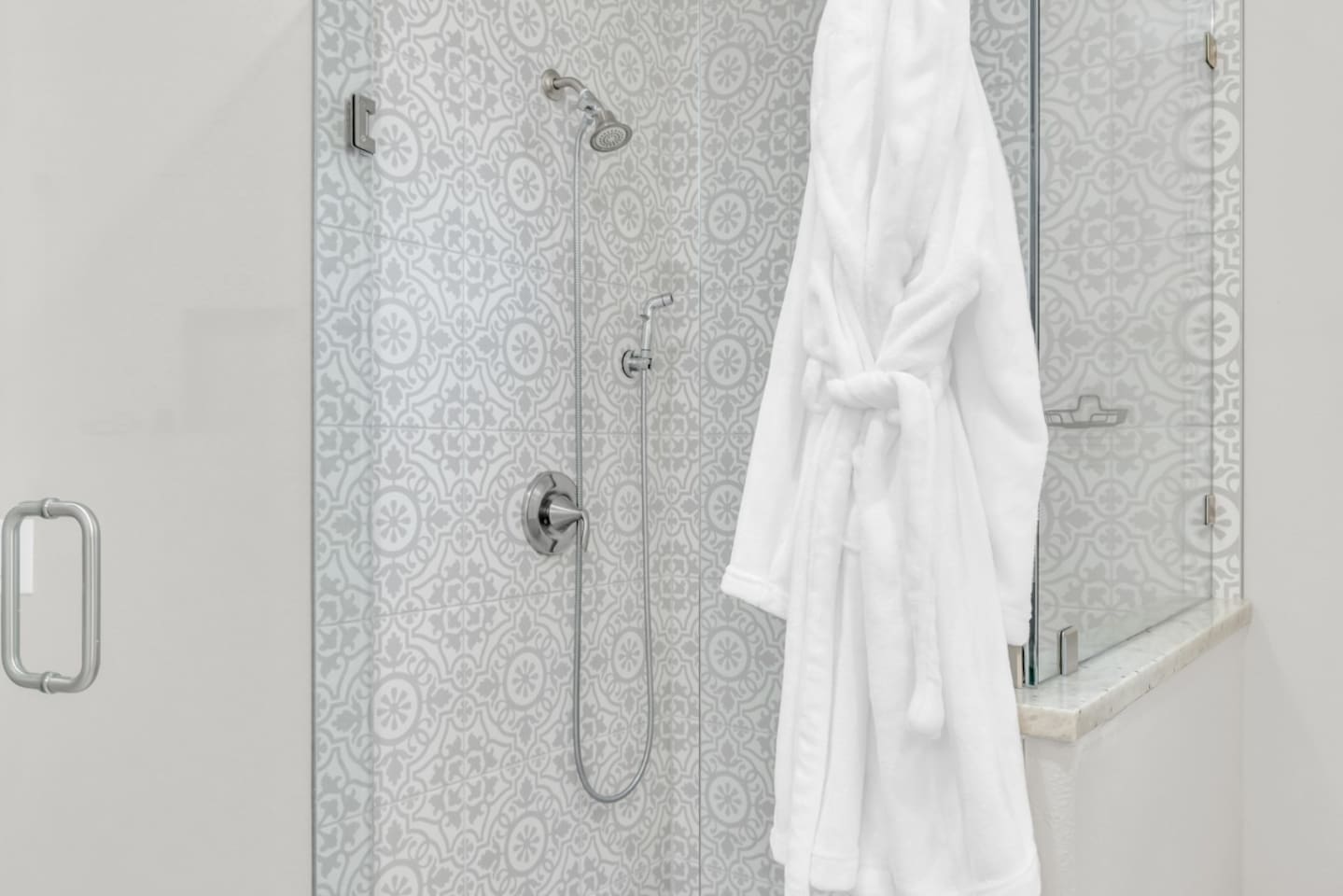 Walk-in shower with rainfall head and plush robe.