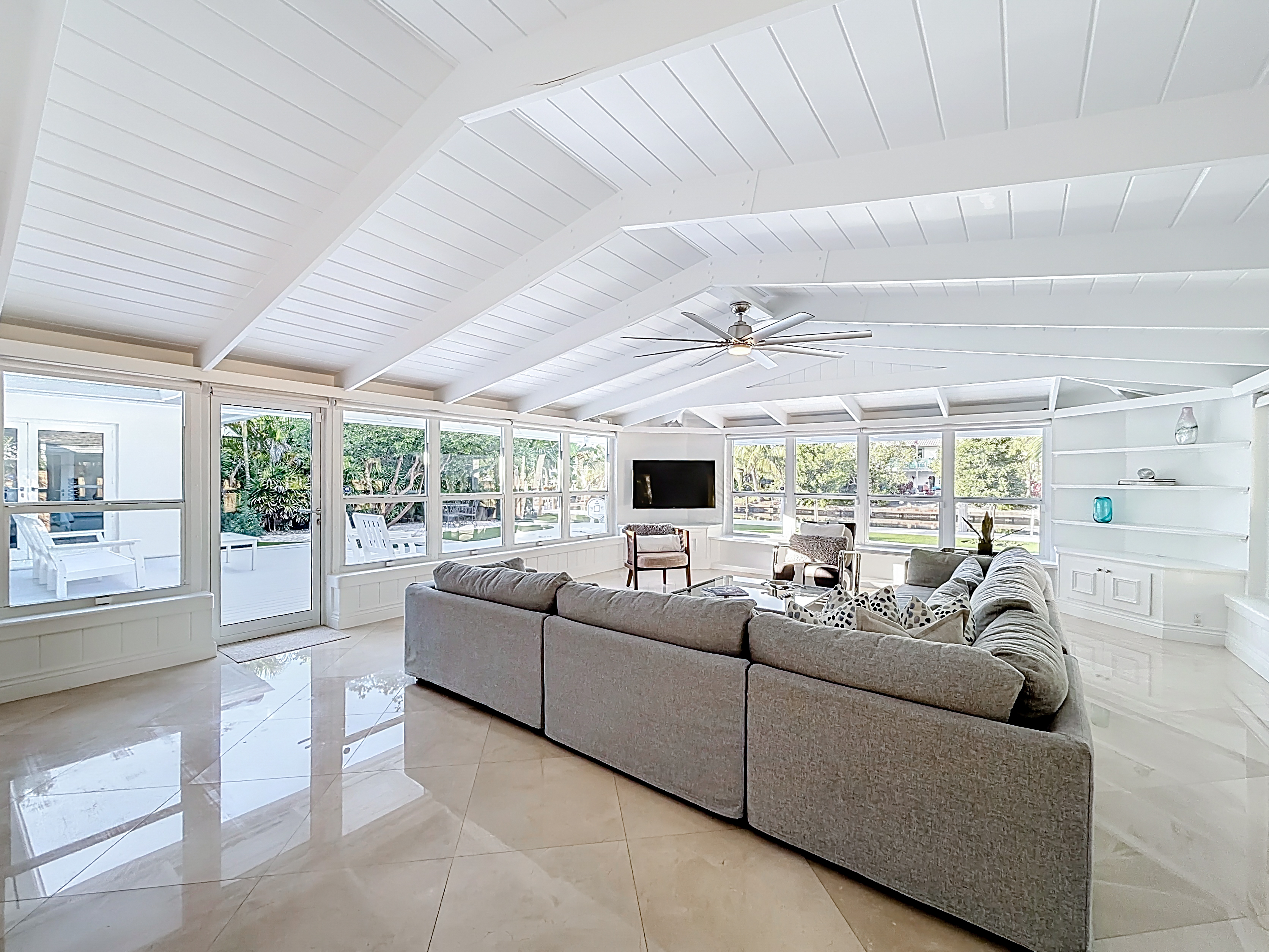 Livingroom with an amazing wraparound view- Pool, water, a true tropical setting. Sit on the wrap around bench and feel practically outside. 