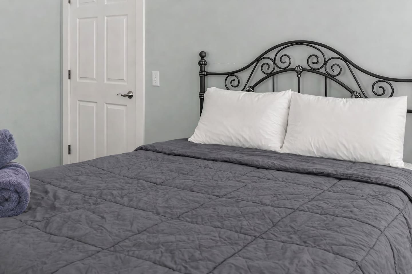 Detailed look at the queen bed and headboard, showcasing comfort and classic design touches.