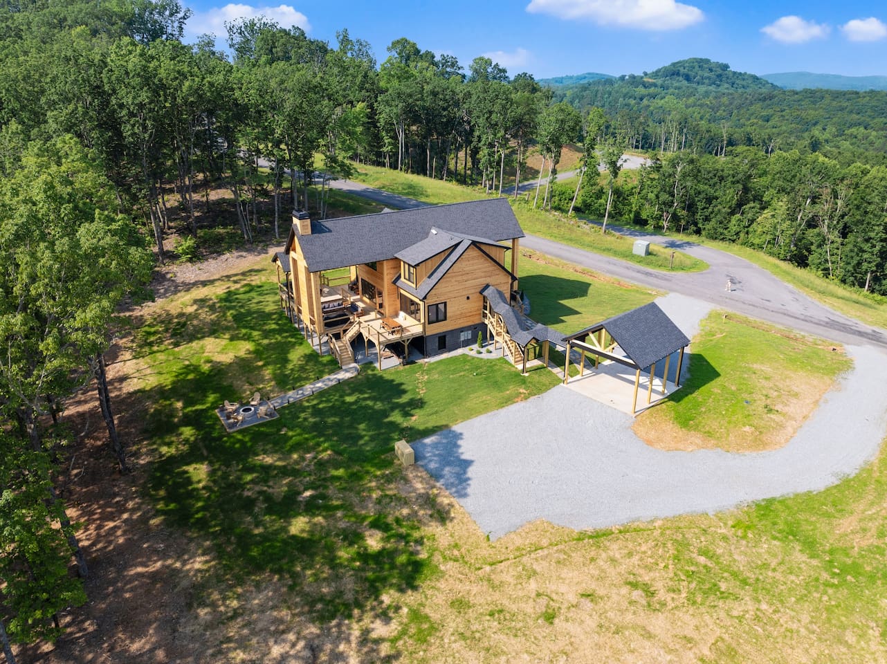 Experience the cabin’s full grandeur and serene location—this aerial shot captures the expansive property, mountain views, and winding road access.
