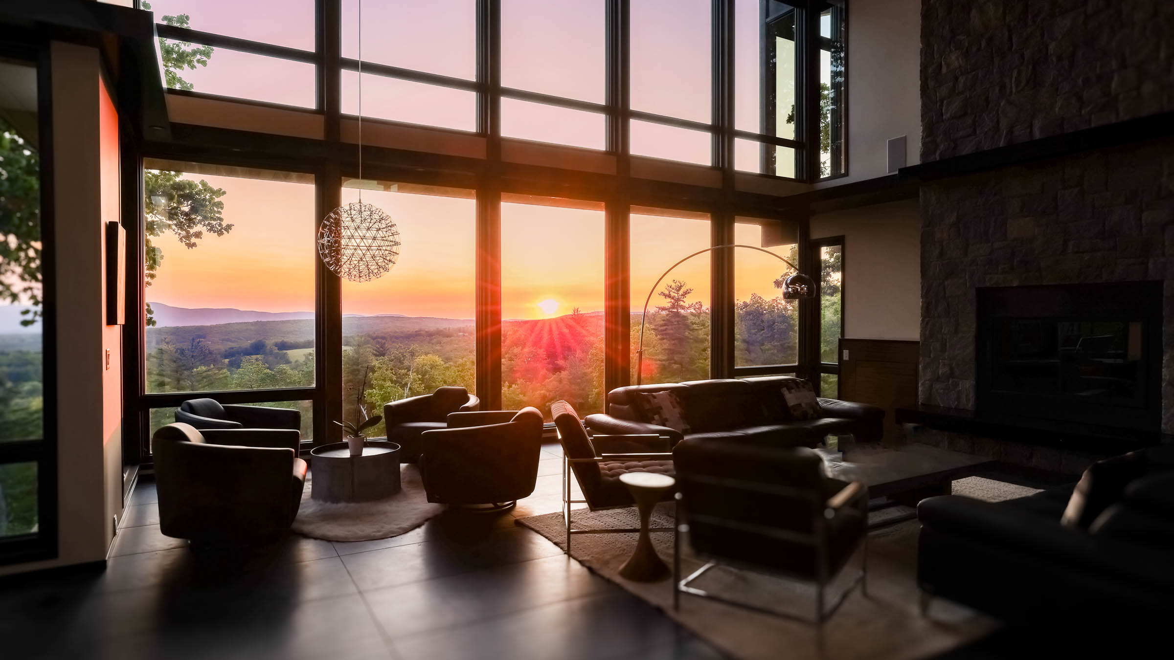 Great Room at sunset &mdash; floor-to-ceiling glass, valley horizon, Sunset Falls Berkshires