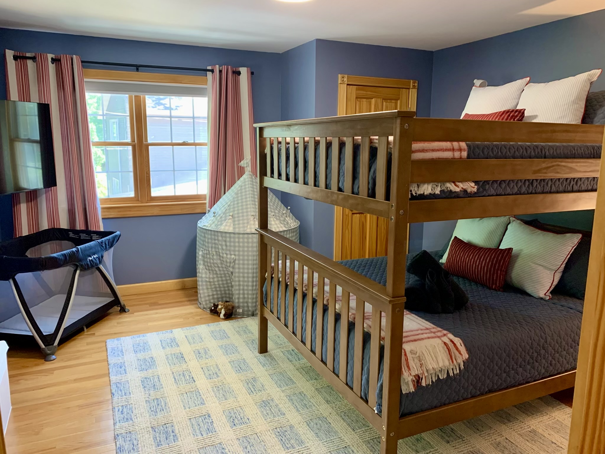 Our queen-over-queen bunk room combines spacious sleeping with family-friendly touches, including a smart TV, play tent, toy chest, Pack 'n Play.