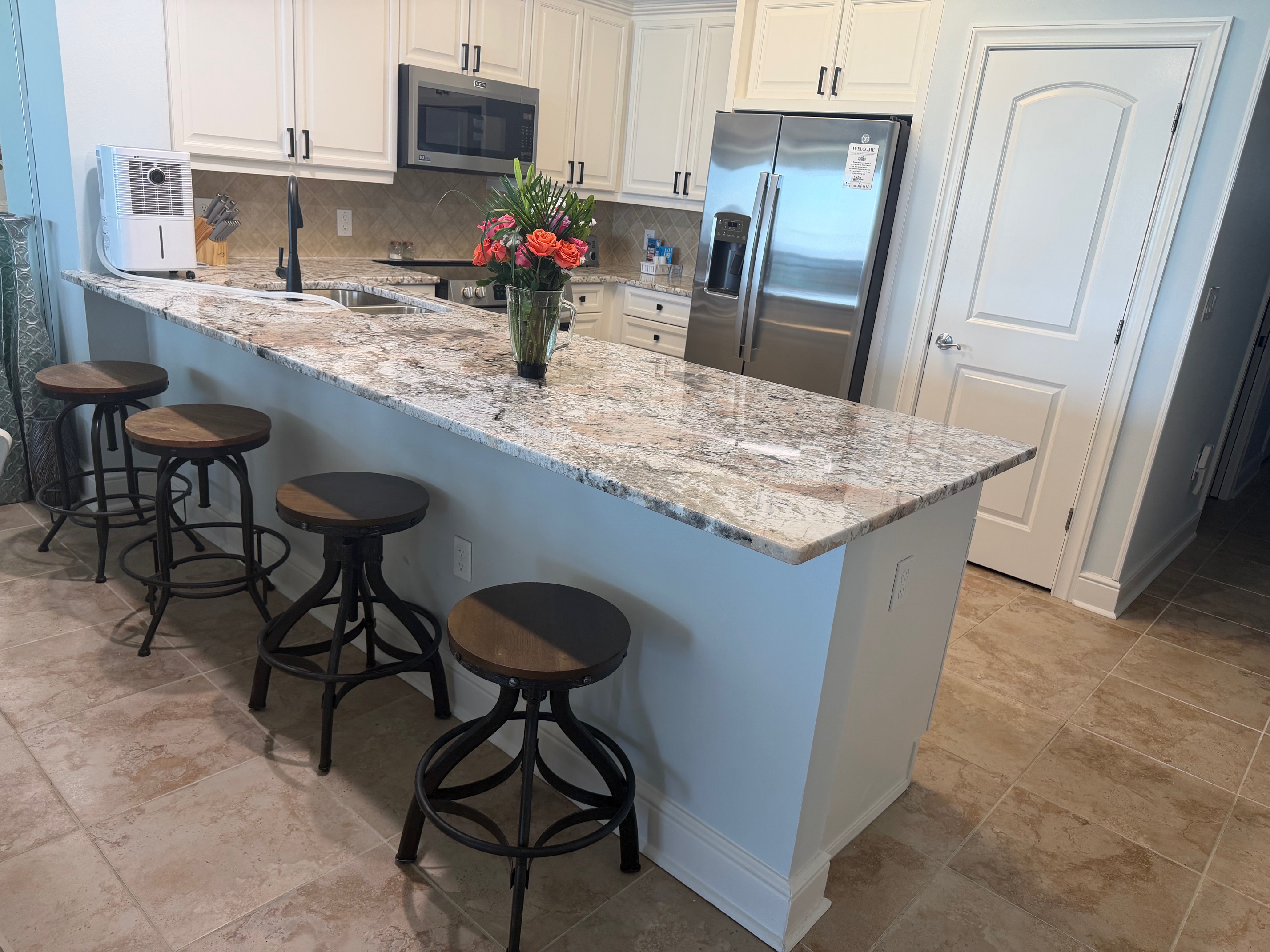 Spacious kitchen with granite countertops, stainless appliances, and bar seating—perfect for coffee mornings or family meals together.