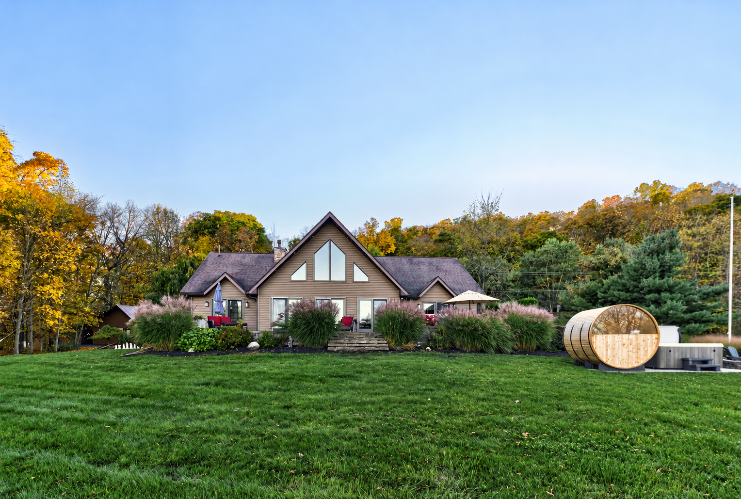 Rear exterior with expansive lawn and barrel sauna