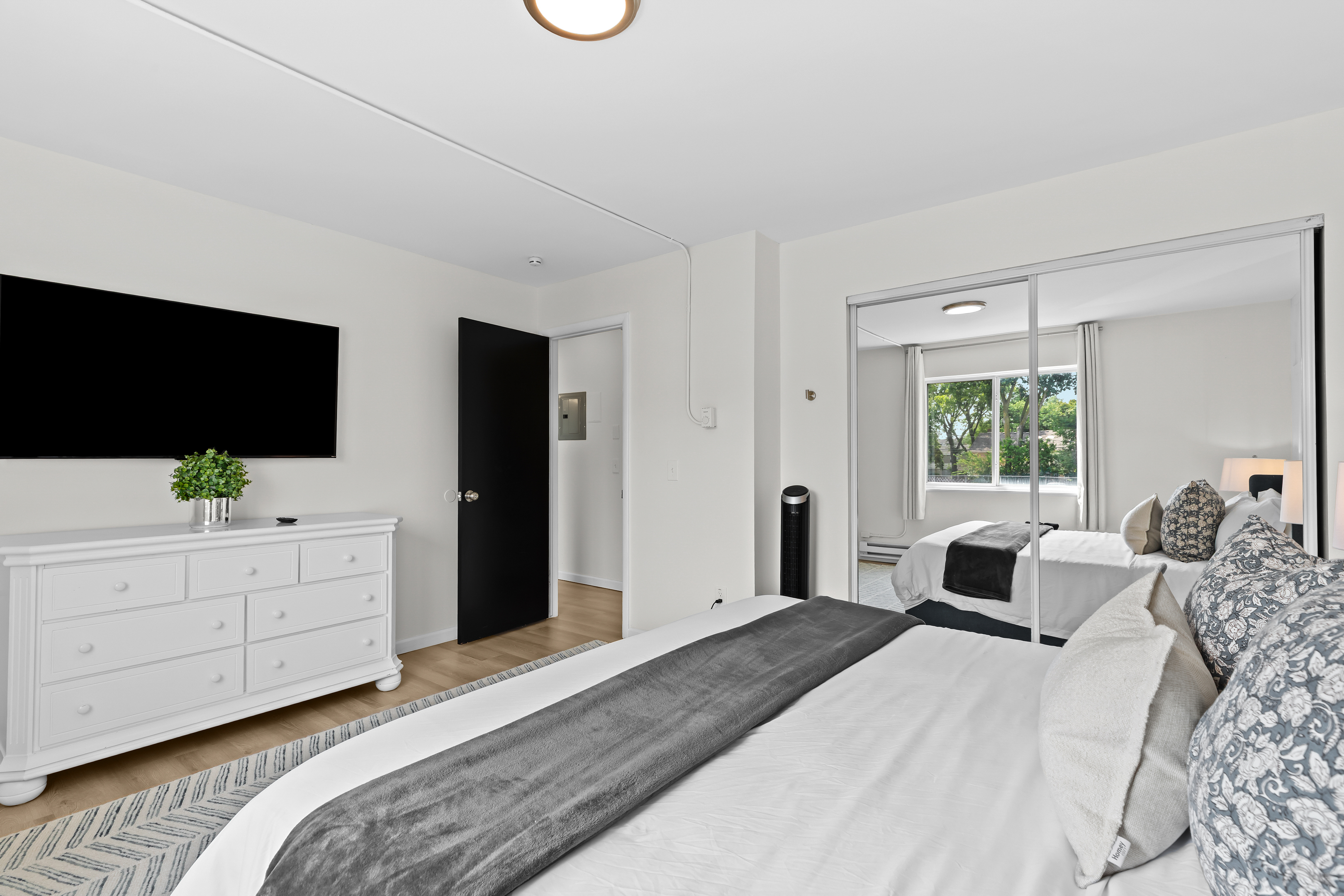 Cozy guest bedroom with a comfortable bed, dresser, and wall-mounted TV for private entertainment.