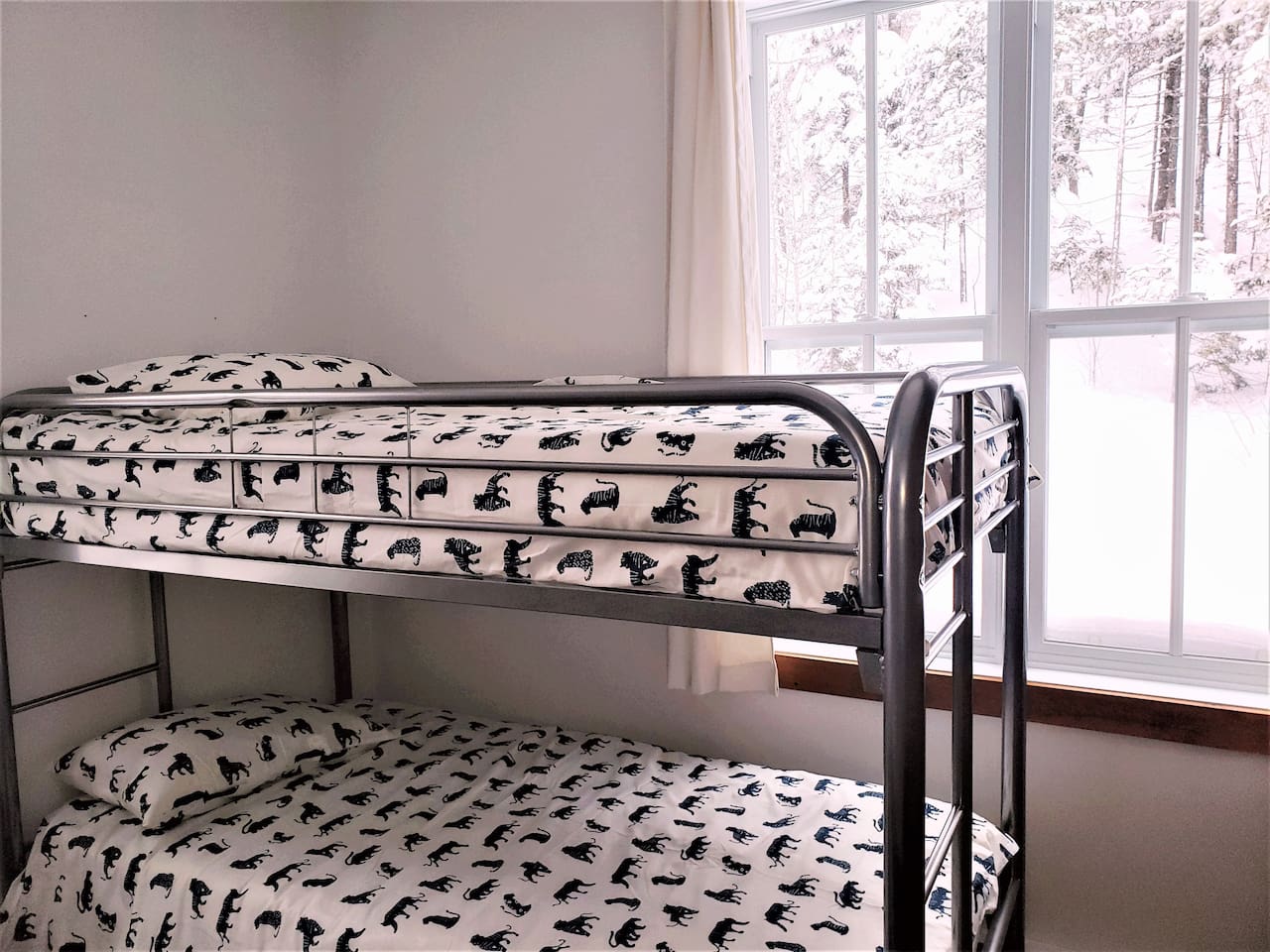 Chambre #2 au rez-de-chaussée avec un lit queen et un lit superposé.