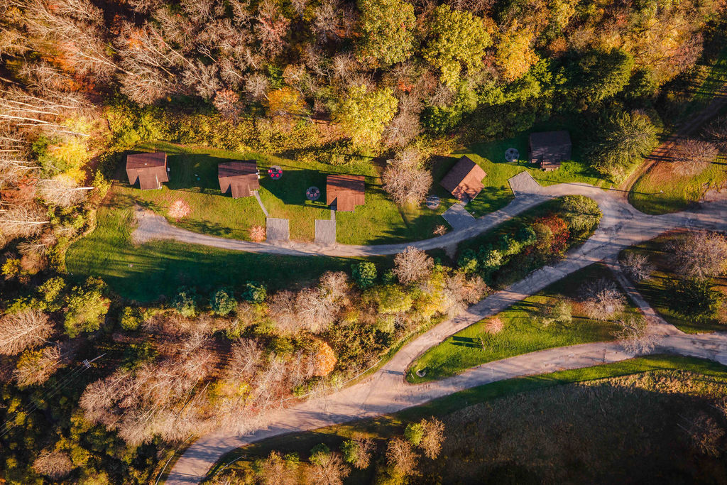 A quiet row of rustic cabins tucked into the forest—DentonGo Cabin #2 sits trailside, ready for your next adventure.