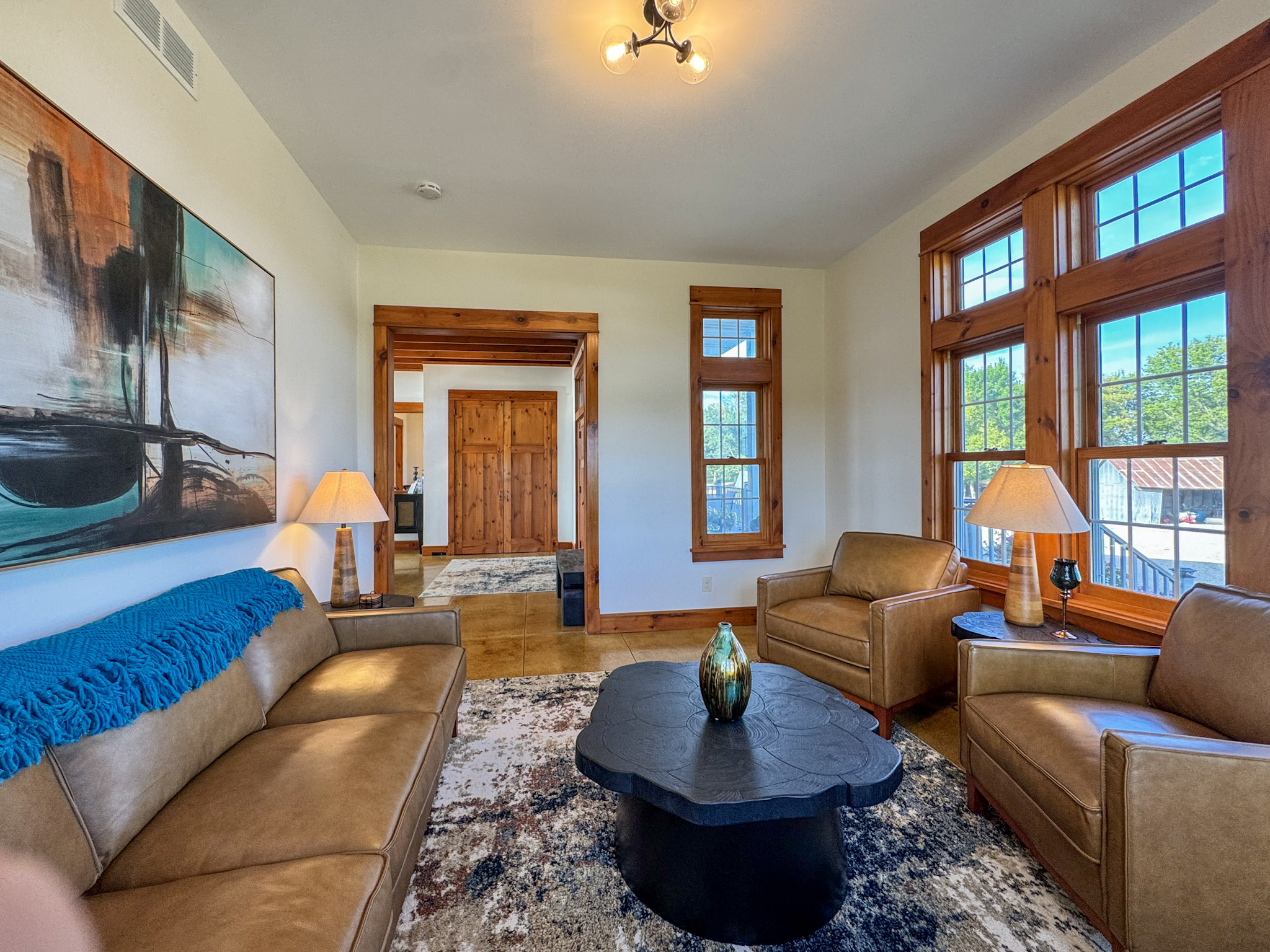 Front sitting room with leather seating and large windows.