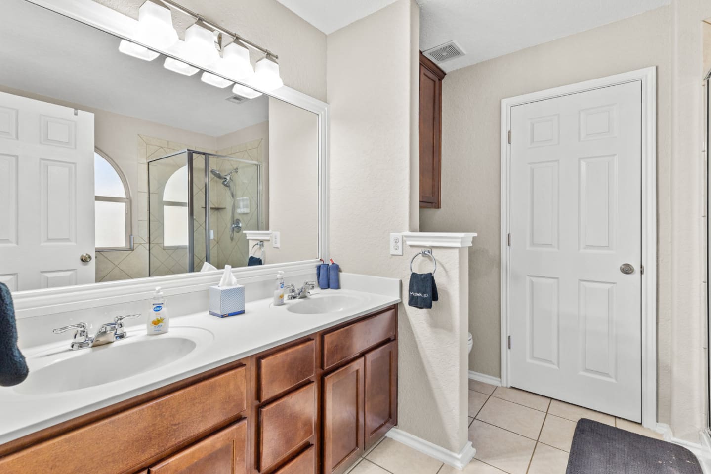 Spacious master bathroom with double vanity, ample counter space, and premium Ginger Lily Farms toiletries for a comfortable stay.