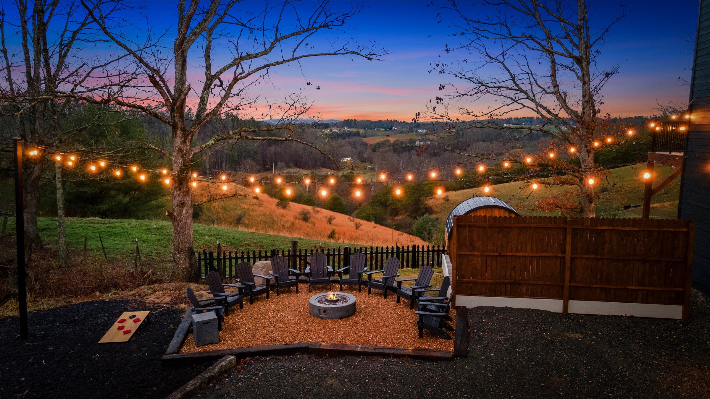 {Gather} Outdoor gathering space with fire pit, string lights, and mountain backdrop — designed for memorable evenings.