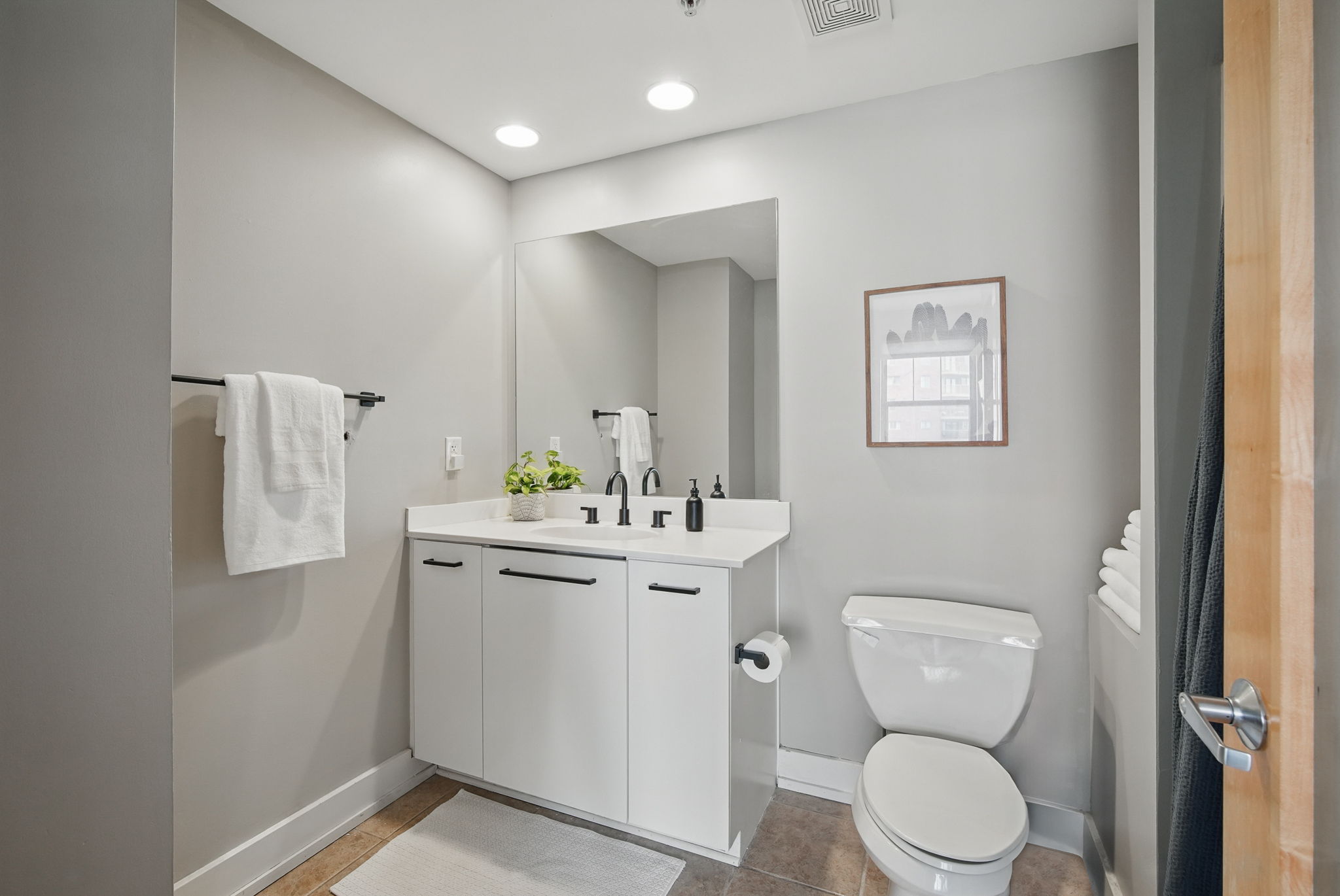 Bright, clean bathroom with a large mirror, soft lighting, and modern fixtures. Includes plush towels, essential toiletries, and thoughtful design for a relaxing start and end to your day.