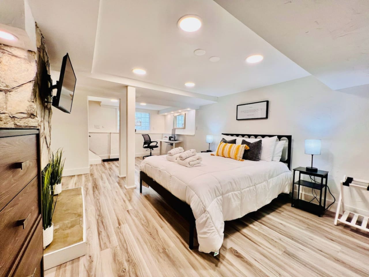 Spacious queen-sized bedroom with a dedicated working space and a TV, offering the perfect blend of comfort, productivity, and entertainment.