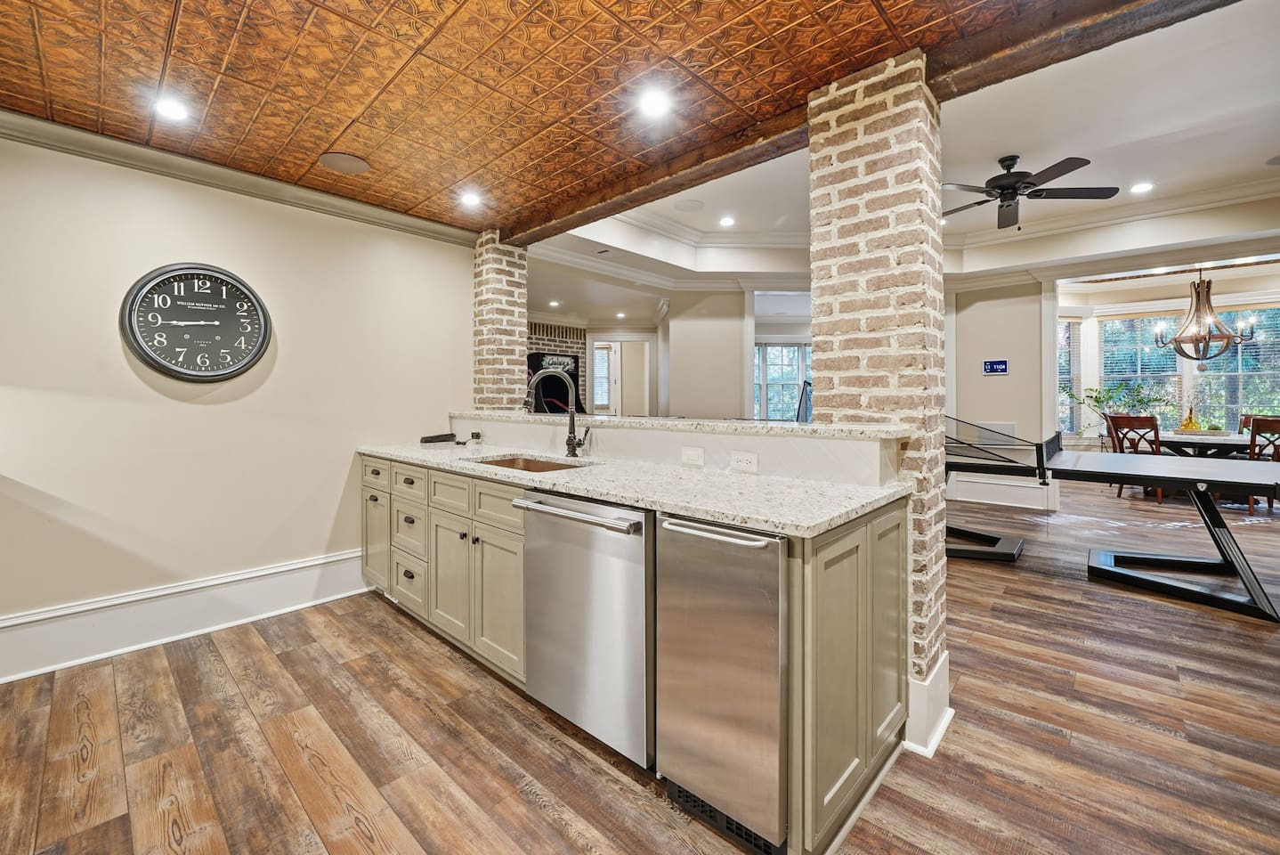 This luxurious kitchenette is designed for easy living, featuring a TV, sink, full fridge, and beverage cooler. Perfect for preparing light meals, grabbing refreshments, or enjoying a cheerful moment located within the game room.