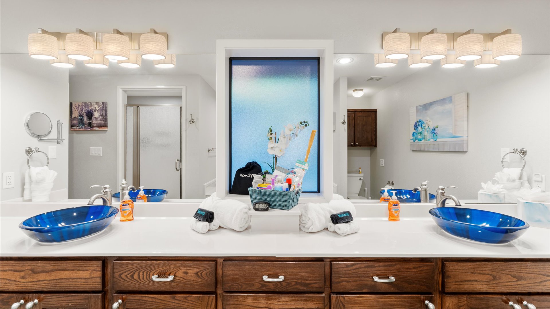 King 1 Bathroom has custom sinks, great lighting, a makeup mirror, and a "forgot something" basket with essentials like a hair dryer, razors, and more. Fresh towels and Kleenex are provided.