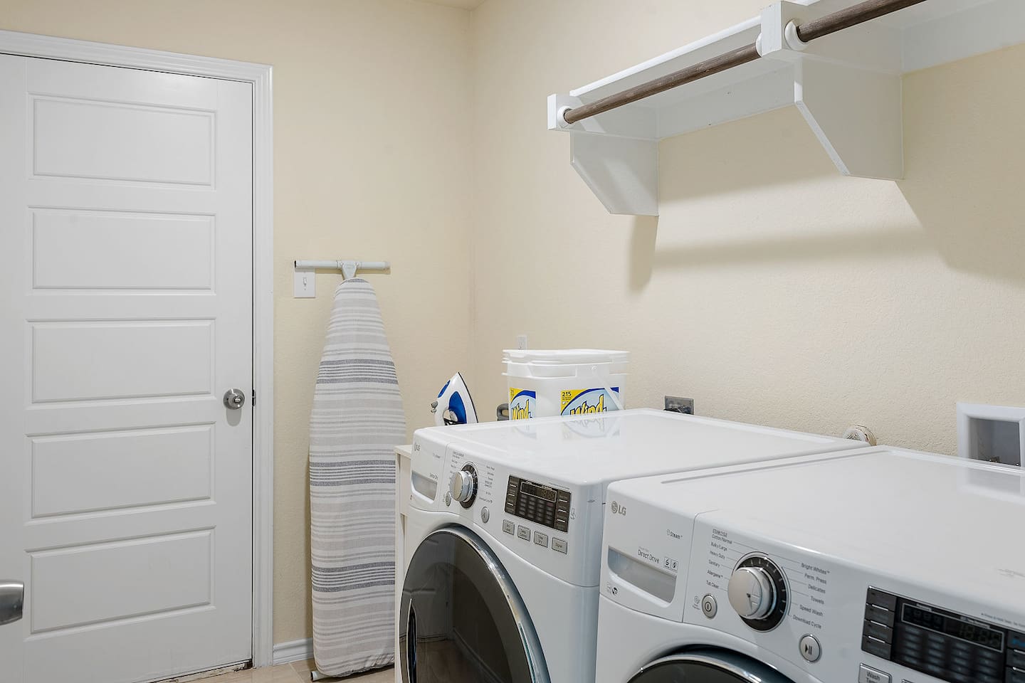 Enter a functional laundry room equipped with modern washer and dryer units for your convenience.