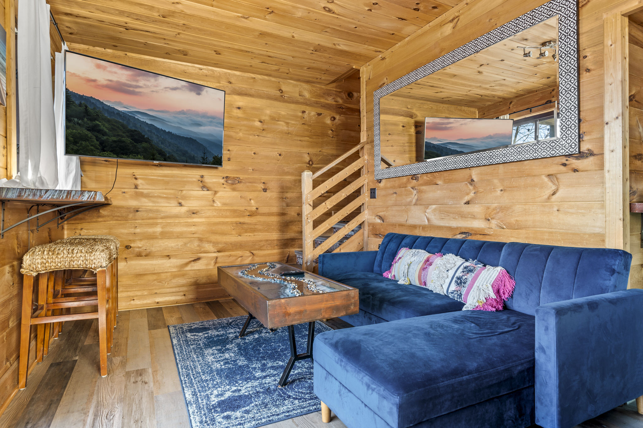 A cozy, modern couch completes the game room area perfectly situated in front of a large smart tv.