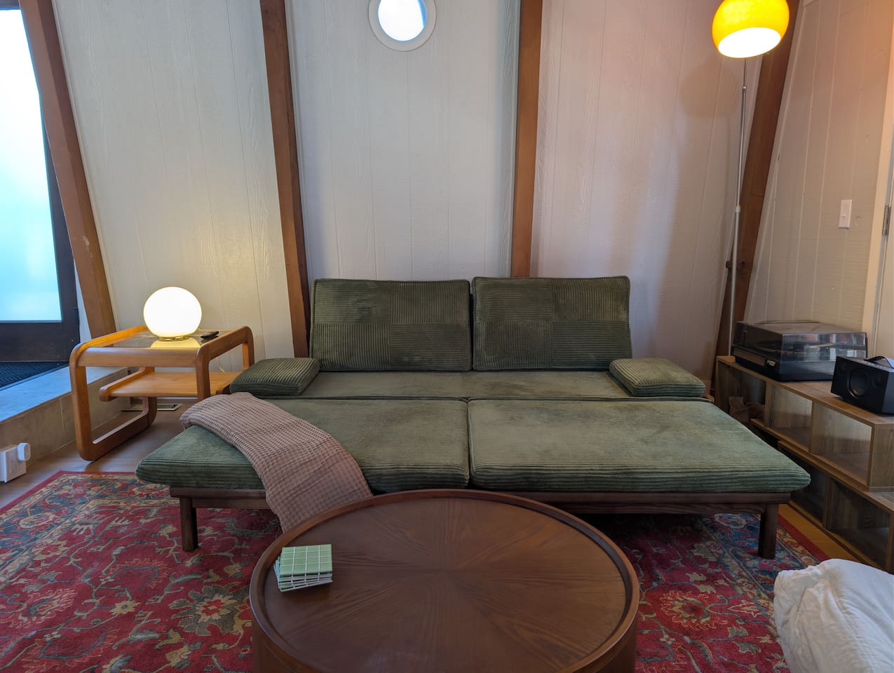 Relax in style. This green corduroy sofa easily expands into a cozy lounger during the day, and an extra sofa bed at night. Additional bedding is stored in the upstairs closet.