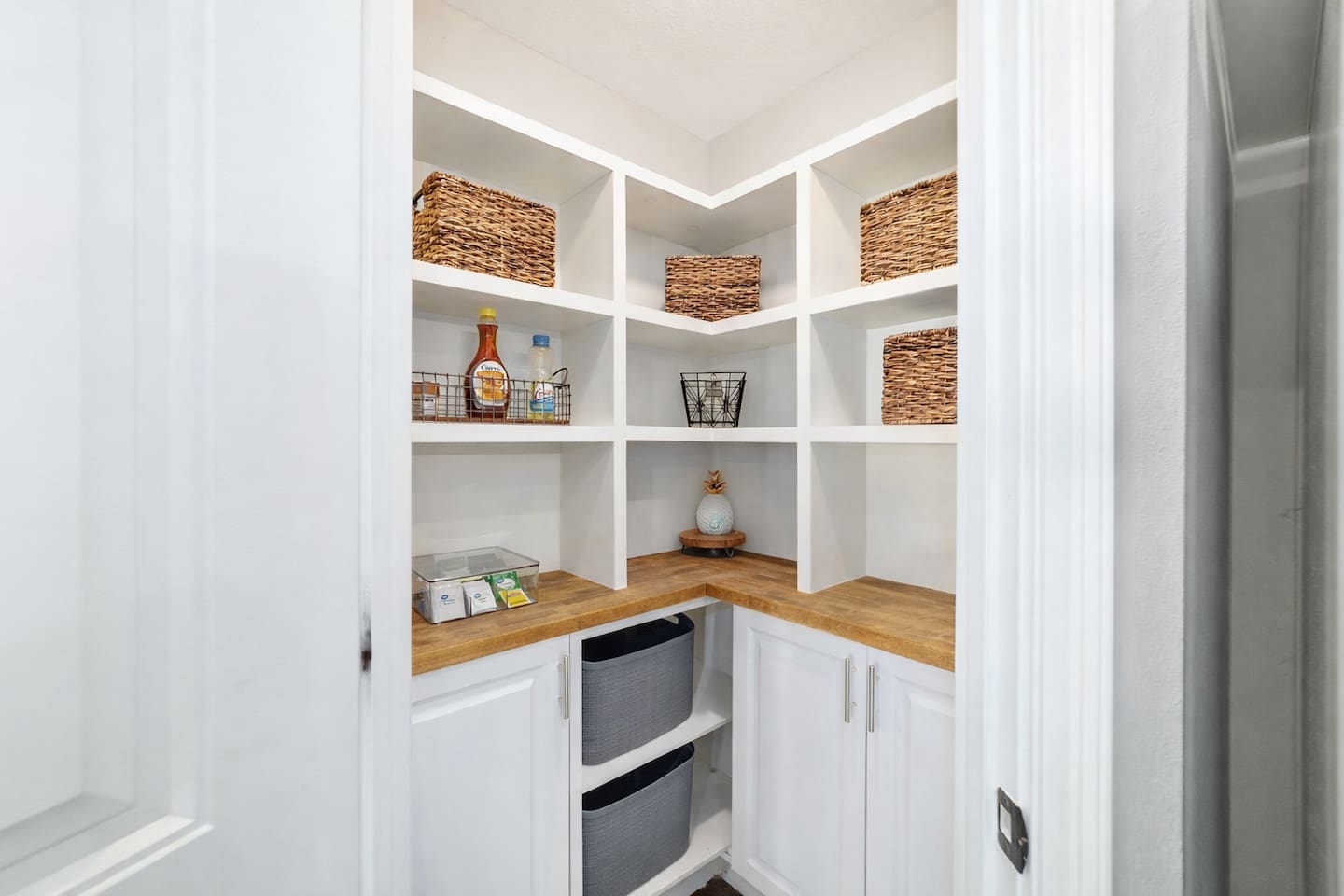Enjoy this custom pantry featuring open shelving, labeled baskets, and ample storage for all your cooking essentials. With plenty of space to keep groceries tidy and easy to access, this pantry adds both function and charm to your stay.